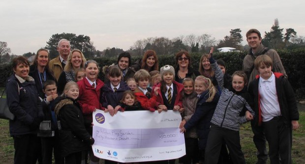 School children holding £50,000 ITV People's MIllions Reward for Winton Play Garden
