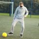This is a photo of a Bournemouth University student attempting to control the ball whilst blindfolded. He was taking part in a blind football taster session.