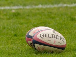Photo of 2 rugby balls on a rugby pitch