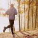 Photo of a man running along side a lake