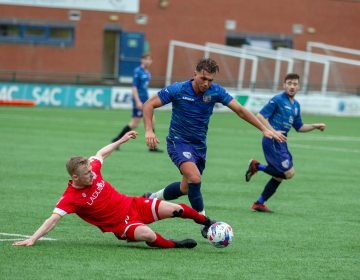 An attempt at a tackle is made in a football match