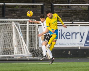 Two football players try to win a header