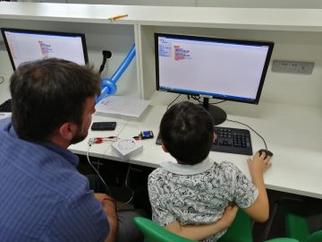 A student and a teacher sat at a computer