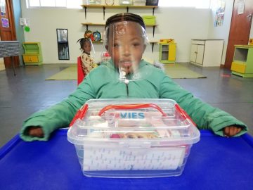 Child sat wearing a face shield