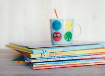 Stack of children's books with mug on top