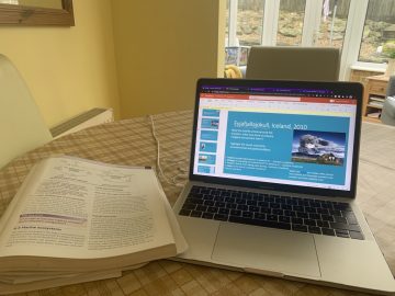 A laptop and a textbook on a table