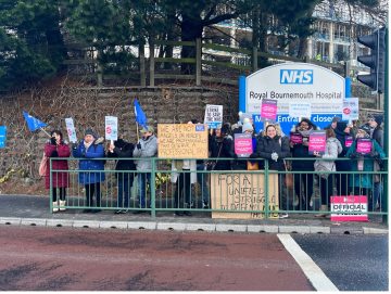 NHS workers holding signs that are striking against the government.
