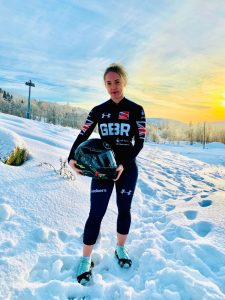 Photo of Rebecca Hannibal stood in the snow in her olympic uniform. 