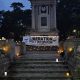 A 'Liberation not Occupation' banner held up at Bournemouth War Memorial. There are several candles surrounding it.