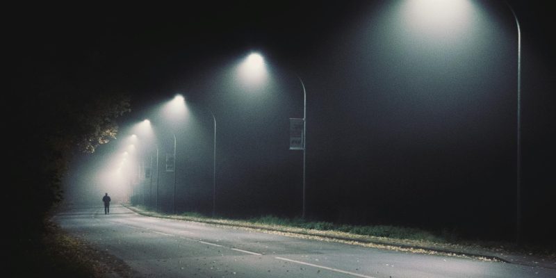 Man walks down dark alleyway