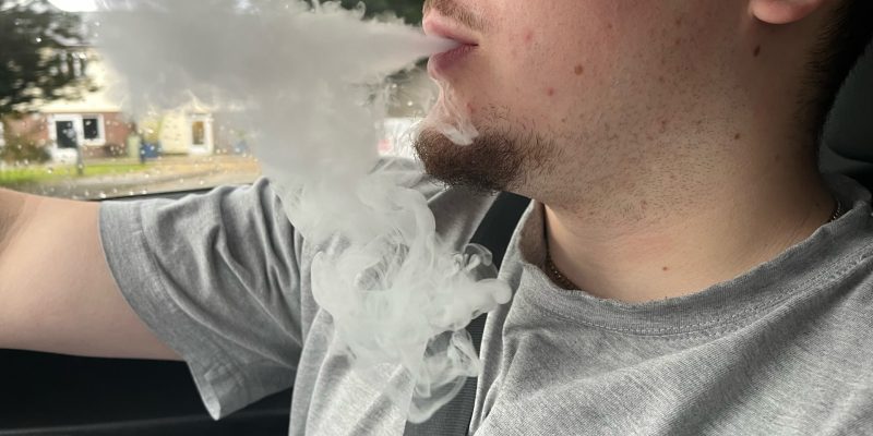 man smoking disposable vape