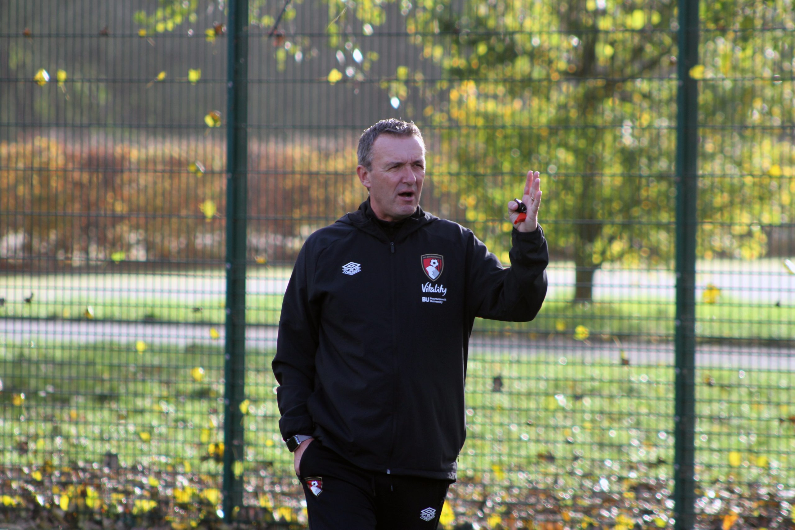 Steve Cuss standing on his own speaking whilst holding his red whistle