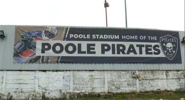 A banner for Poole Pirates outside Poole Stadium, it says 'Poole Stadium, home of the Poole Pirates'