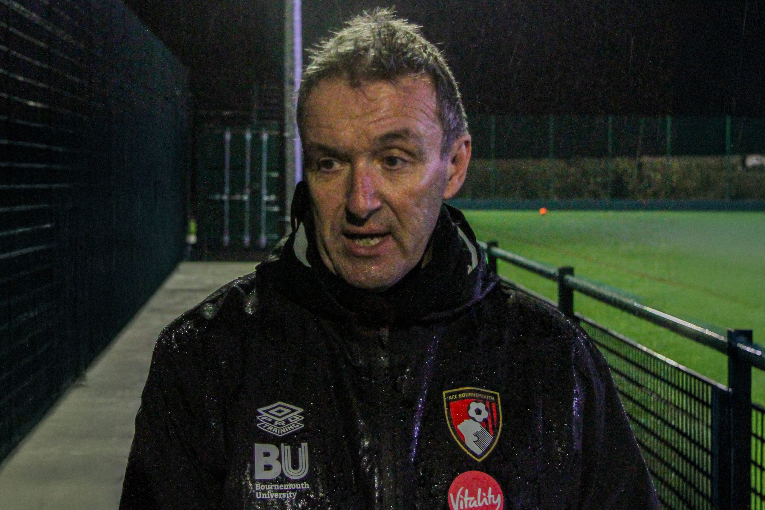 Steve Cuss stood in the rain wearing a black waterproof jacket with a BU sponsorship on his jacket