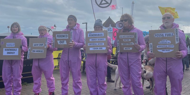 Extinction Rebellion stood holding placards outdoors.