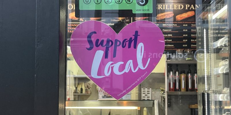 Sign that says "support local" on a bakery window