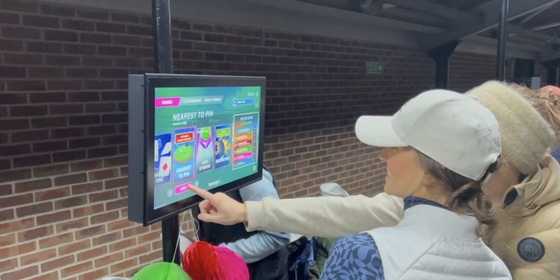 Female golfers gathering around Inrange screen at Iford