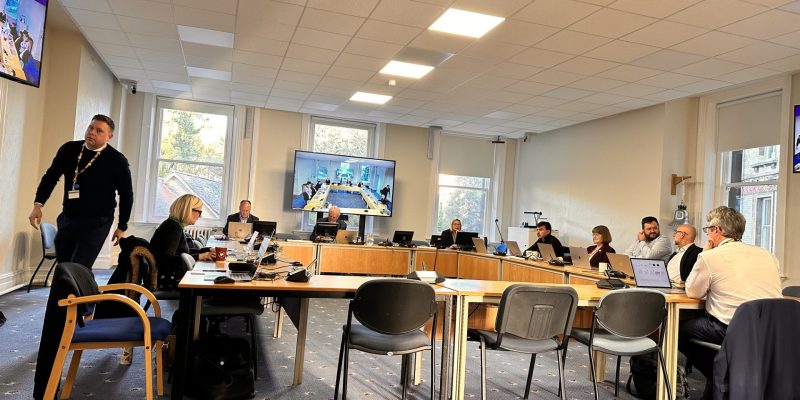 Four Long tables in a square formation with people dotted around