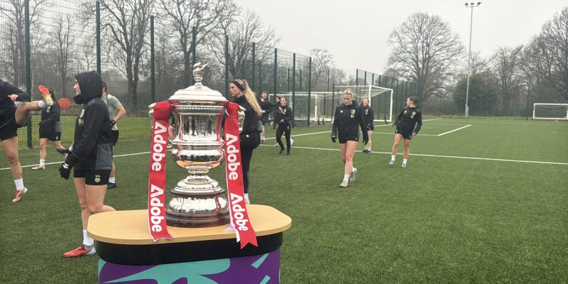 AFC Bournemouth women warming up next to the WFA Cup trophy.