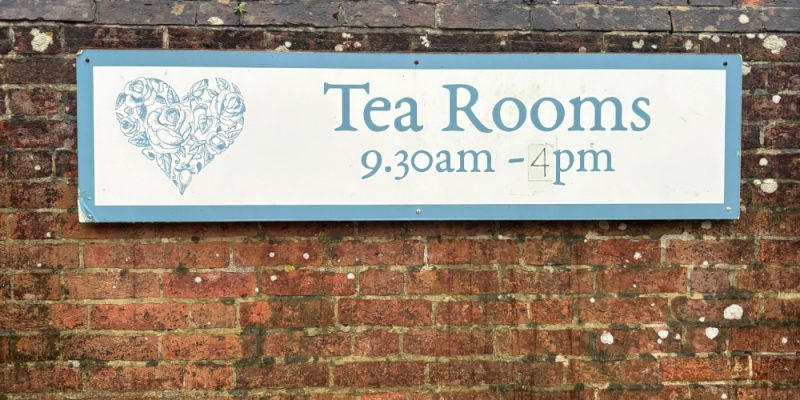 redbrick wall with a tea room sign in blue and white