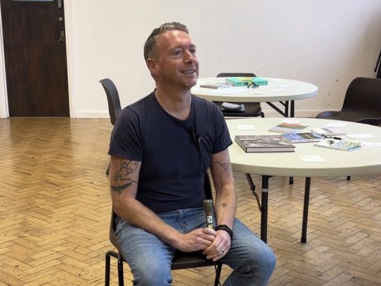 man in a blue t-shirt sat on a chair