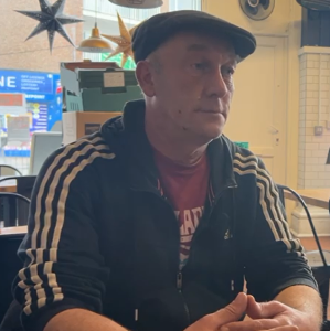 image of an older man in a blue adidas jacket along with a bule hat